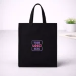 Black cotton tote bag with sturdy handles suitable for corporate gifting and employee welcome kits