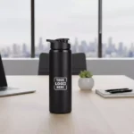 Sporty steel water bottle black 750 ml placed on office desk suitable for corporate gifting and employee welcome kits